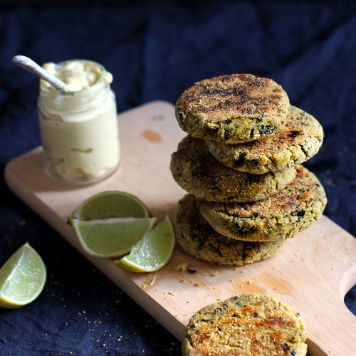 Portugese vegan viskoekjes op een plank met limoenpartjes en een sausje